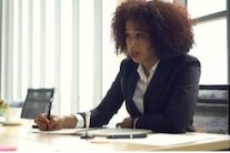 woman sitting at desk listening to someone else speak