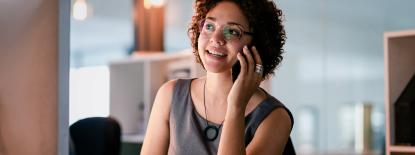 Photo of woman sitting at desk on the phone