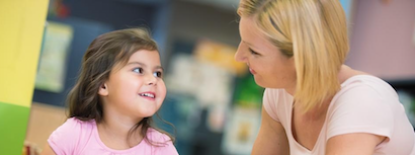 Teacher helping young girl in class