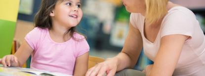 Woman helping child with reading