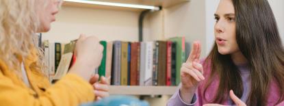 Photo of two people communicating with sign language