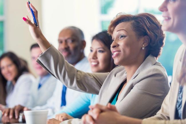 woman raising her hand in a meeting